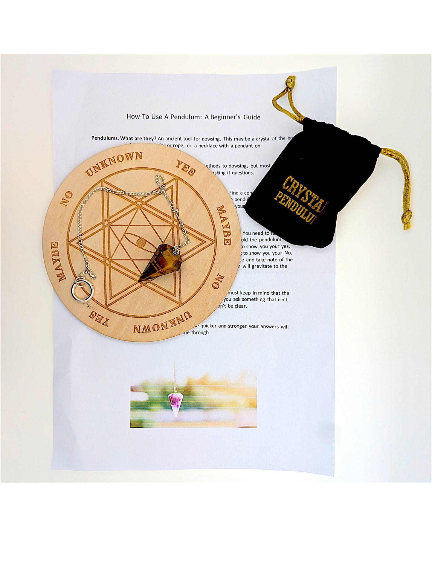 Pendulum Board Set. A complete pendulum set including a wooden dowsing board, crystal pendulum on chain, drawstring storage.
